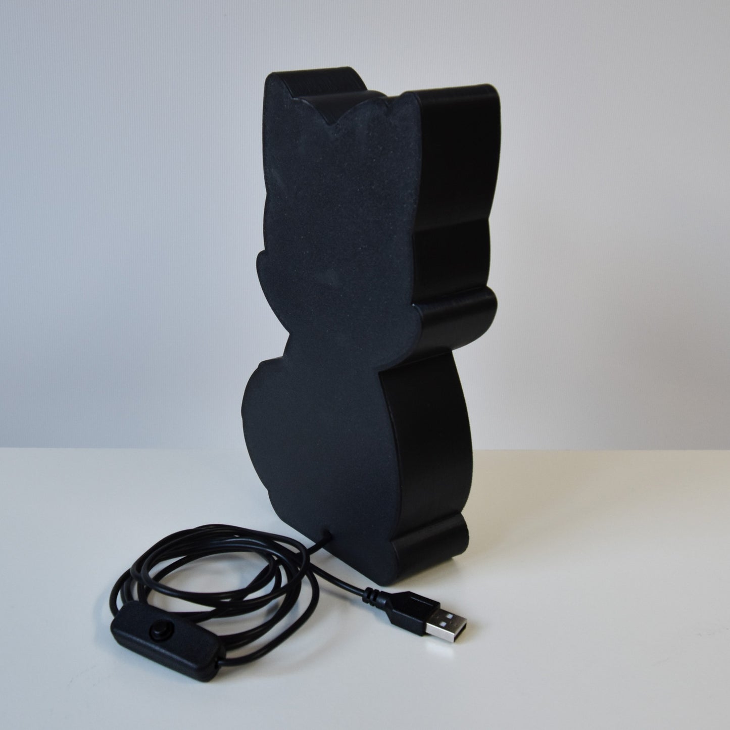 schwarze Rückseite der Katzenlampe mit USB-Kabel und Schalter