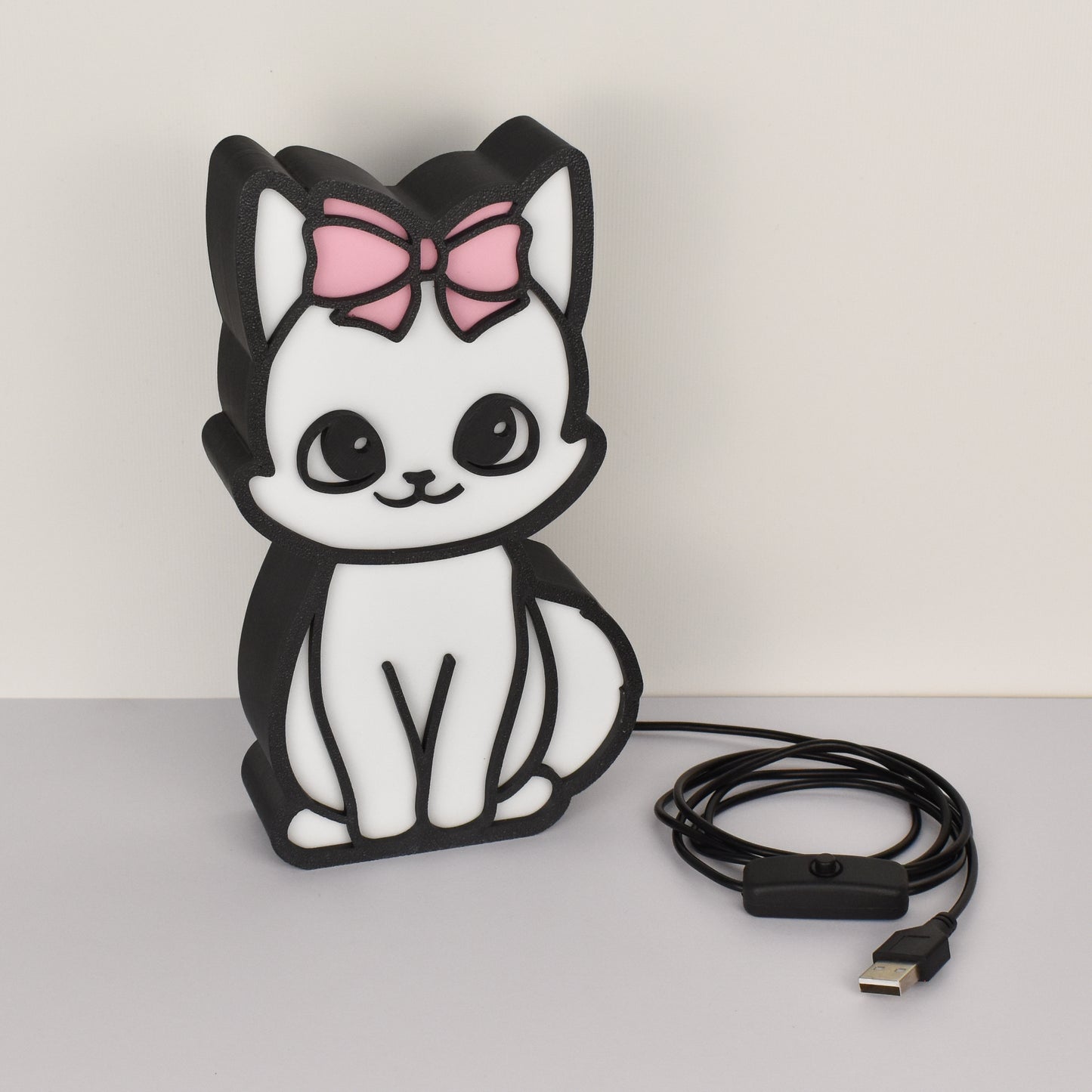 USB Katzenlampe mit rosa Schleife – ausgeschaltet mit Kabel auf weißem Hintergrund