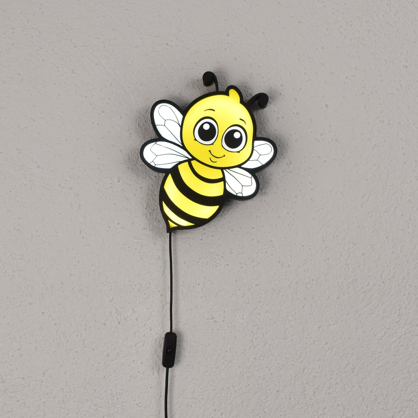 Bienenförmige LED-Wandleuchte leuchtet an einer weißen Wand – süßes Nachtlicht für Kinder