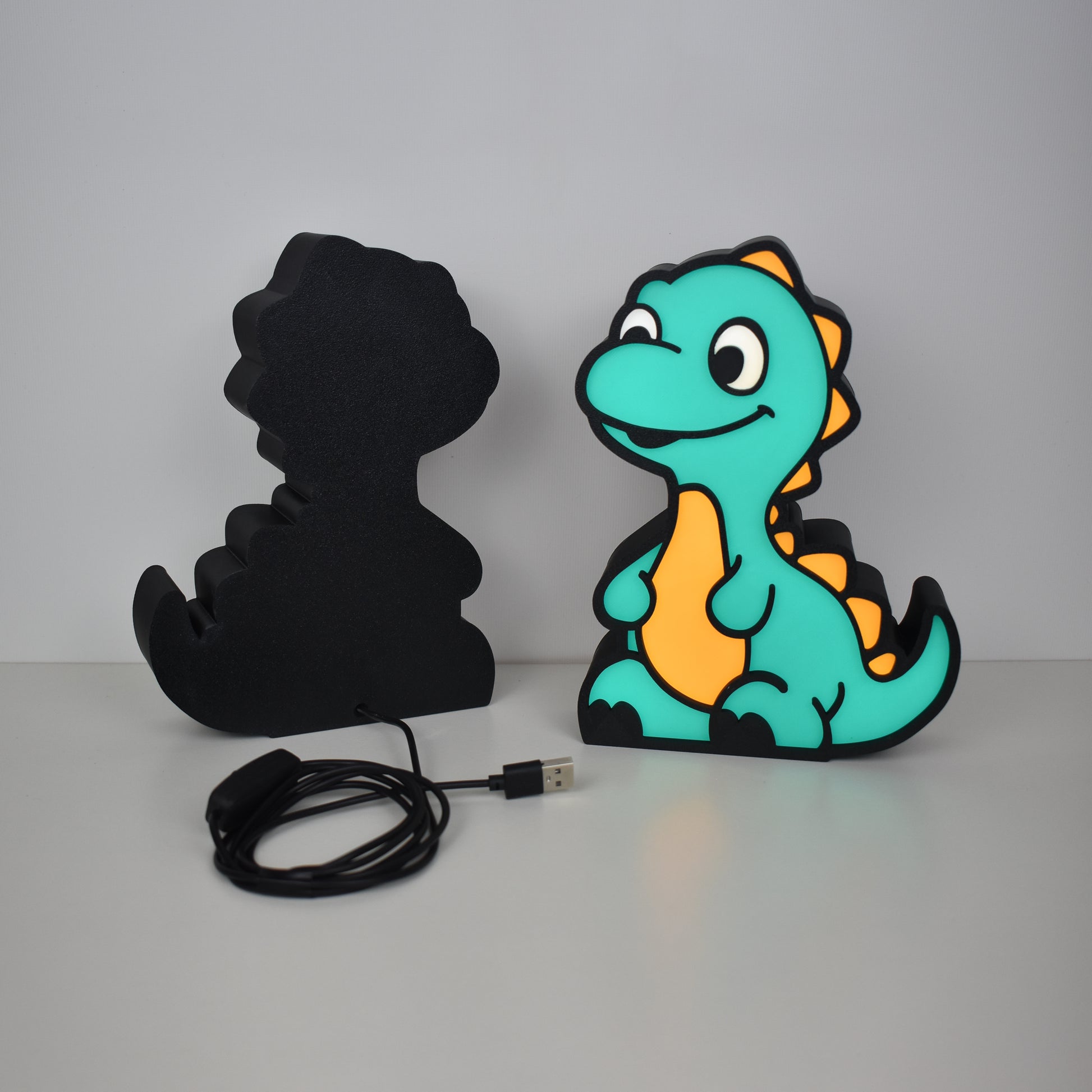 Rückansicht der Dino-Lampe mit schwarzem Gehäuse und USB-Stromkabel  